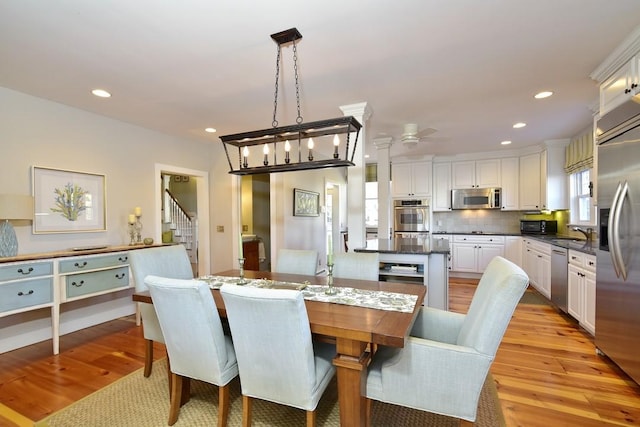 dining room featuring ceiling fan, light wood-type flooring, and sink