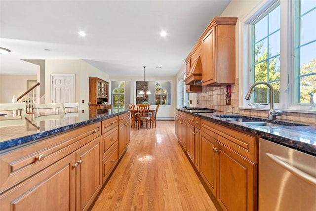 kitchen featuring decorative light fixtures, sink, appliances with stainless steel finishes, and dark stone counters