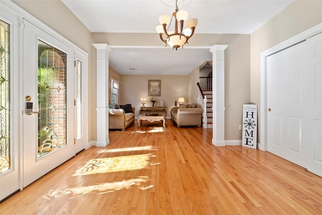 interior space featuring light hardwood / wood-style floors, ornate columns, and an inviting chandelier