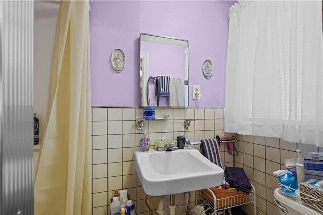 bathroom with sink, tile walls, and toilet