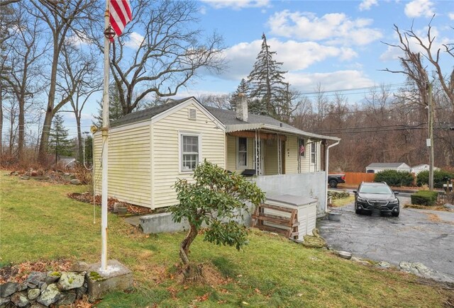 view of front of property featuring covered porch and a front lawn