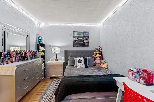 bedroom with crown molding and light hardwood / wood-style floors