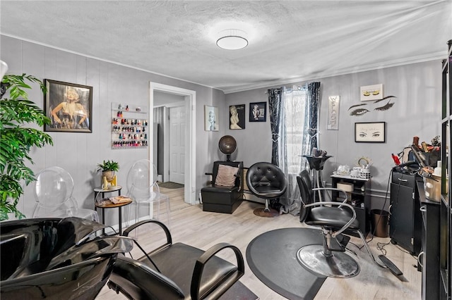 workout area with a textured ceiling and light wood-type flooring