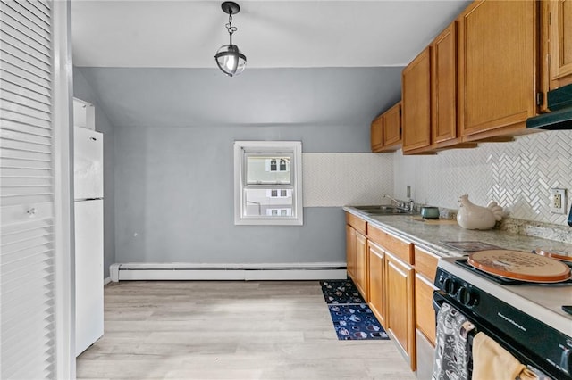 kitchen with decorative light fixtures, sink, white fridge, a baseboard heating unit, and range