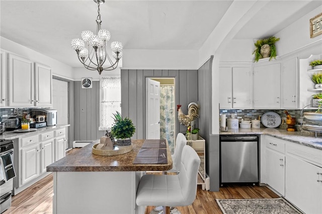 kitchen featuring a kitchen island, white cabinetry, appliances with stainless steel finishes, and tasteful backsplash