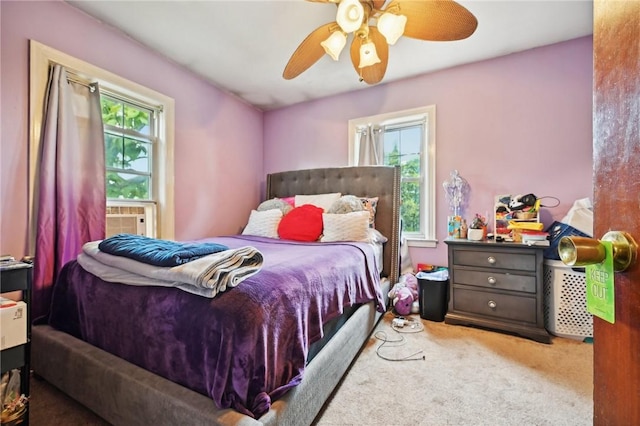 carpeted bedroom with multiple windows, ceiling fan, and cooling unit