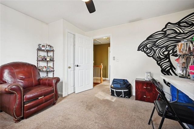 sitting room with ceiling fan and light colored carpet