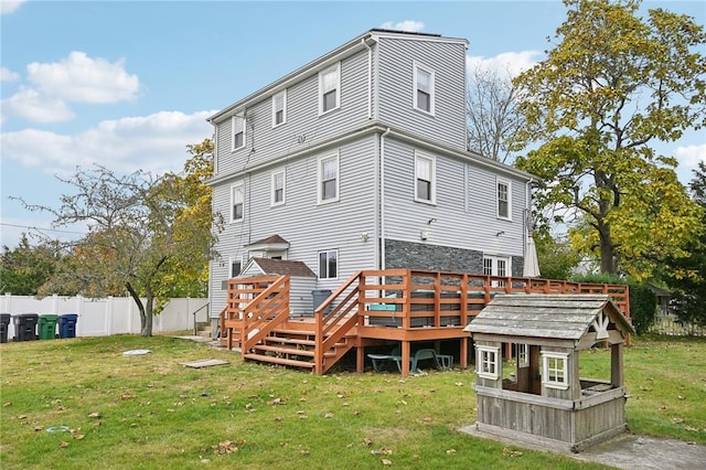 rear view of house with a lawn and a deck