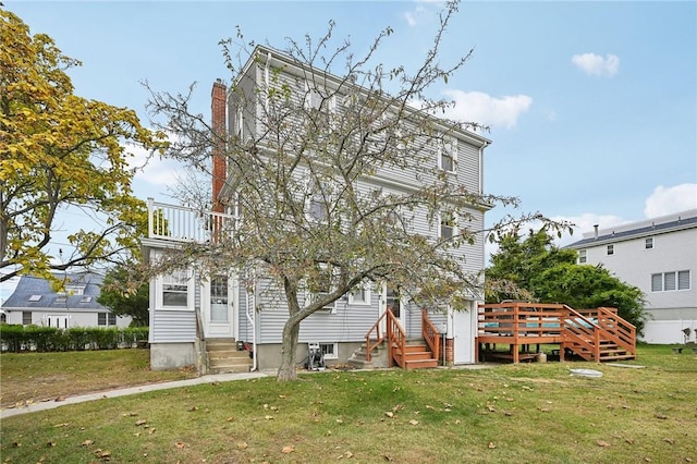 back of property featuring a lawn and a balcony