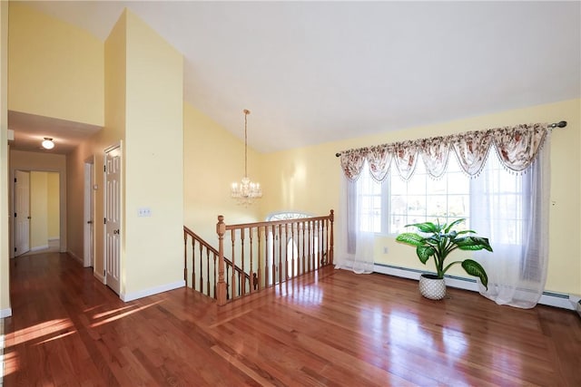 spare room featuring a chandelier, dark hardwood / wood-style flooring, and high vaulted ceiling