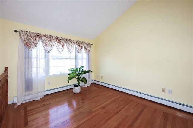 empty room with wood-type flooring, baseboard heating, and vaulted ceiling