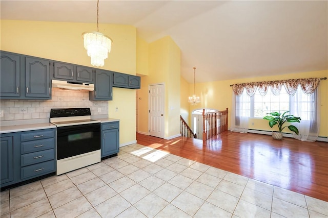 kitchen featuring white range with electric stovetop, tasteful backsplash, vaulted ceiling, and decorative light fixtures