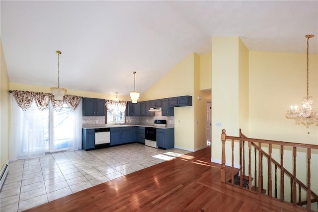 kitchen with white appliances, blue cabinets, baseboard heating, tasteful backsplash, and light tile patterned flooring