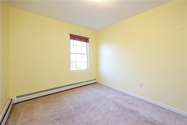 empty room featuring light carpet and a baseboard heating unit