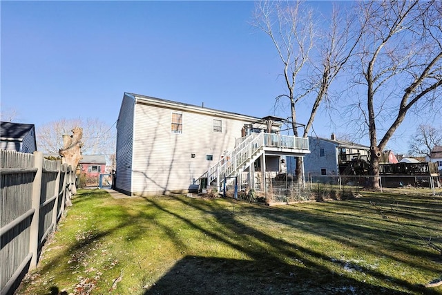 rear view of house with a deck and a lawn