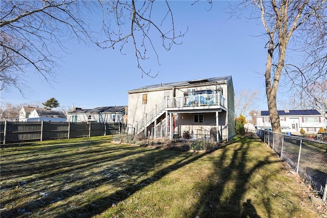 back of property with a yard and a wooden deck