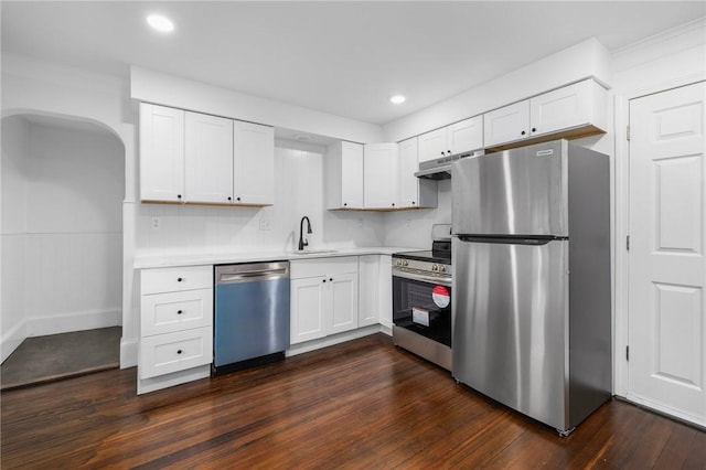 kitchen with appliances with stainless steel finishes, dark hardwood / wood-style flooring, white cabinetry, and sink