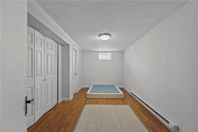 hallway with wood-type flooring and baseboard heating