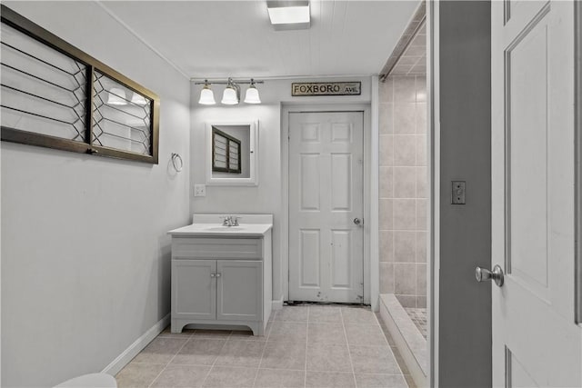 bathroom with tile patterned flooring, a tile shower, and vanity