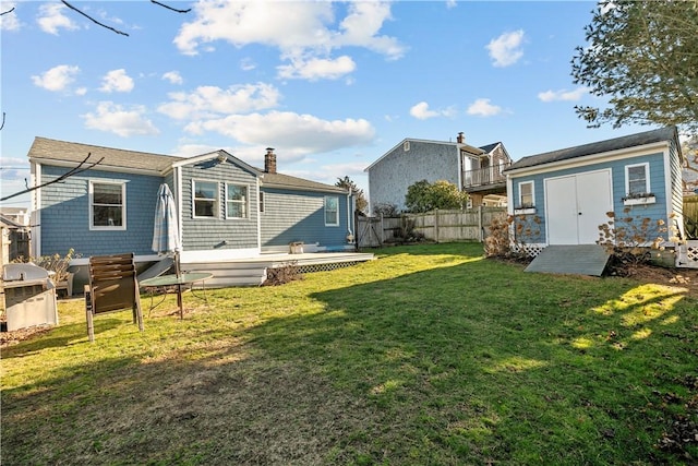 back of house with a shed and a yard