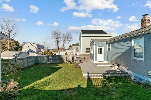 back of house featuring a deck and a lawn