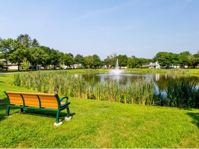 surrounding community with a yard and a water view