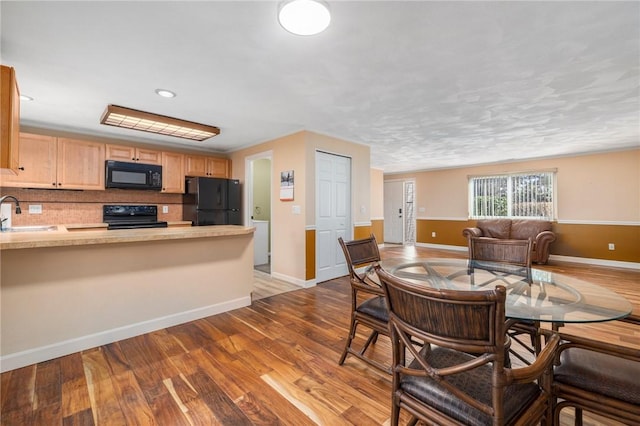 dining area with sink and light wood-type flooring