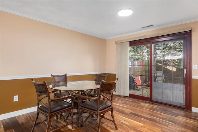 dining space with wood-type flooring and crown molding