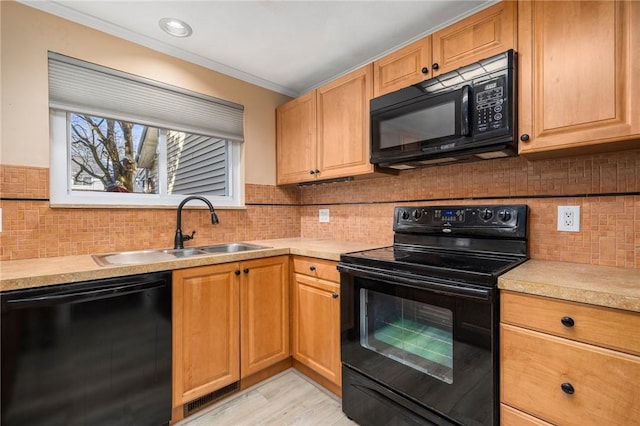 kitchen with tasteful backsplash, sink, black appliances, crown molding, and light wood-type flooring