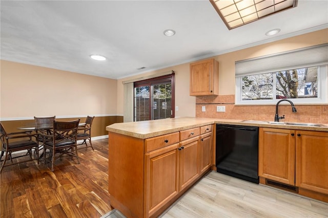 kitchen with sink, light hardwood / wood-style floors, kitchen peninsula, and dishwasher