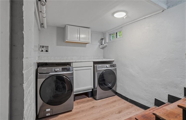 laundry area featuring washer and dryer and light hardwood / wood-style floors