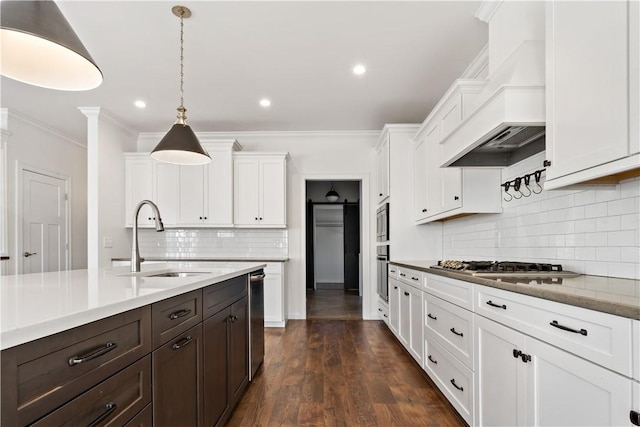 kitchen featuring sink, hanging light fixtures, a barn door, dark hardwood / wood-style floors, and custom range hood