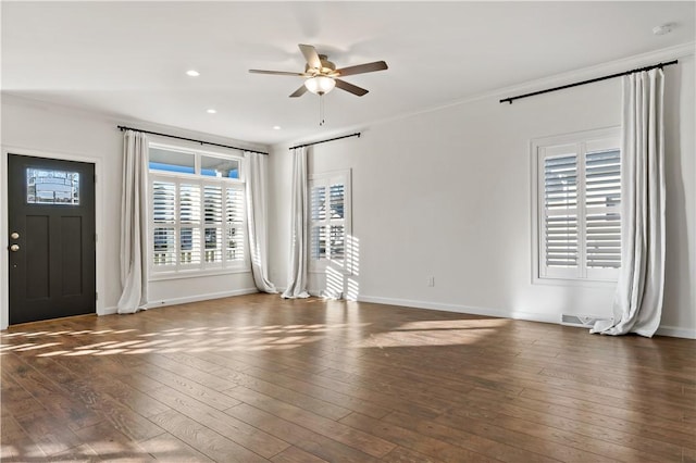 spare room featuring ornamental molding, ceiling fan, and dark wood-type flooring