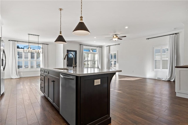 kitchen featuring pendant lighting, a center island with sink, a healthy amount of sunlight, and sink