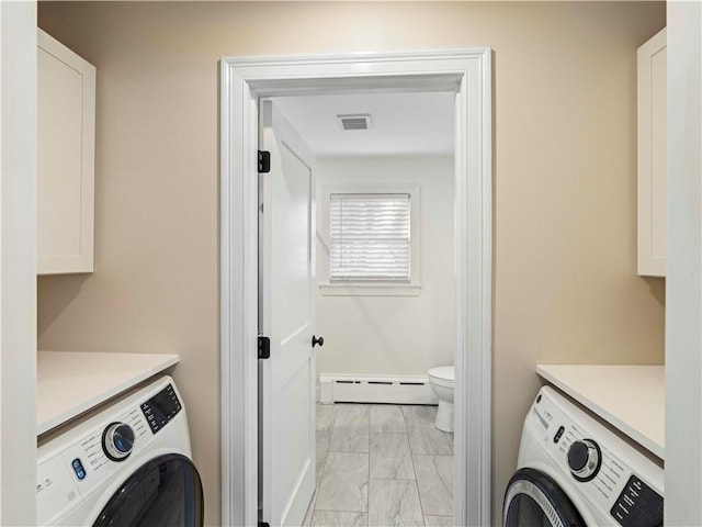 laundry area with cabinets, a baseboard radiator, and washer / dryer