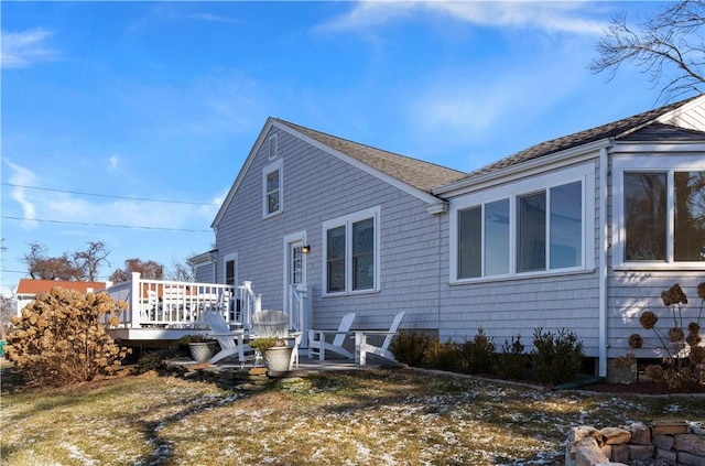 back of property with a lawn and a wooden deck