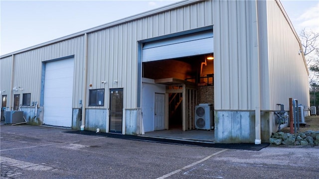 view of outbuilding featuring ac unit, a garage, and cooling unit