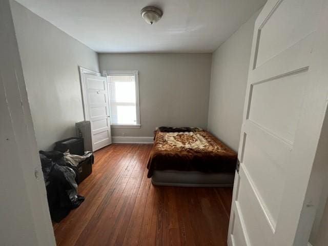 bedroom with dark hardwood / wood-style floors