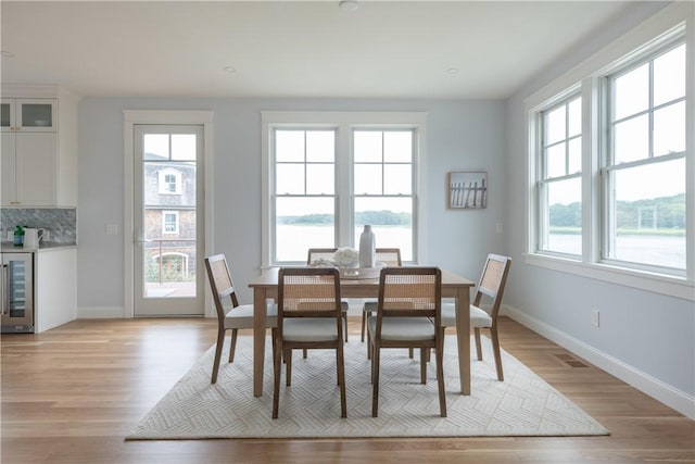 dining room with light wood-type flooring and wine cooler