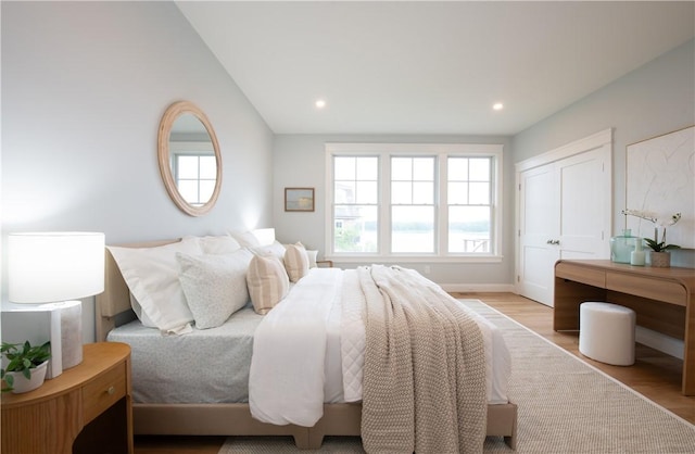 bedroom featuring light hardwood / wood-style floors and lofted ceiling