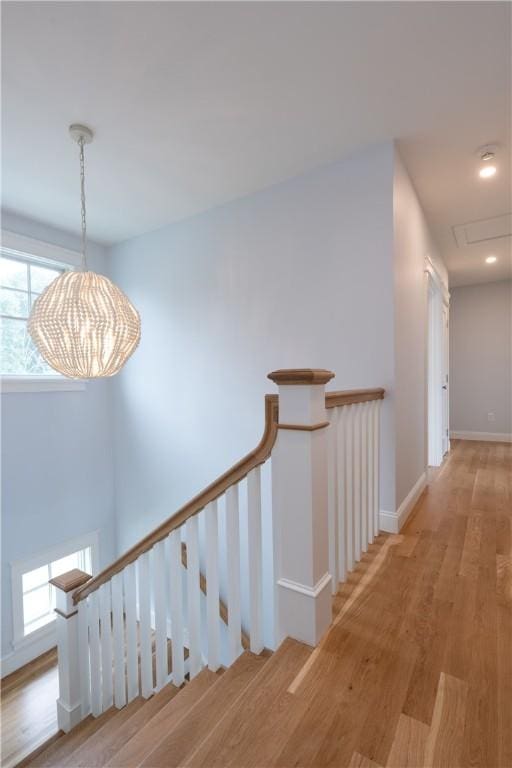 hallway featuring light wood-type flooring and a chandelier