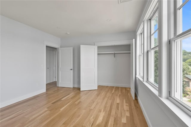 unfurnished bedroom with light hardwood / wood-style floors and a closet