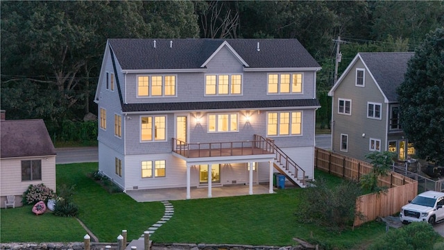 rear view of property featuring a lawn, a balcony, and a patio