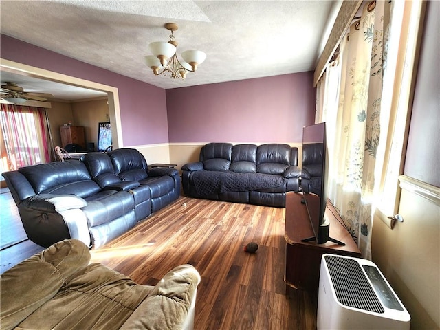 living room with a chandelier, a textured ceiling, and hardwood / wood-style flooring