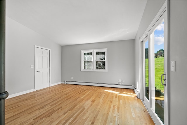 empty room with baseboard heating and light hardwood / wood-style flooring