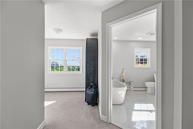 hallway featuring light colored carpet and a baseboard radiator