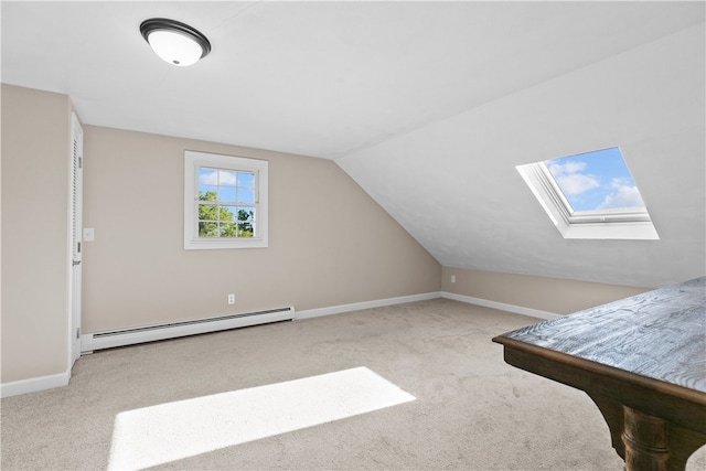 additional living space with baseboard heating, vaulted ceiling with skylight, and carpet