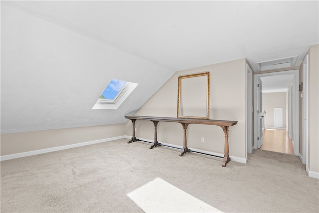 additional living space with light colored carpet and vaulted ceiling with skylight