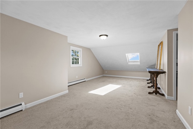 additional living space with a baseboard heating unit, lofted ceiling with skylight, and light carpet