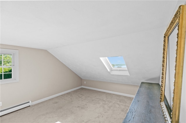 bonus room with a baseboard radiator, vaulted ceiling with skylight, and light carpet